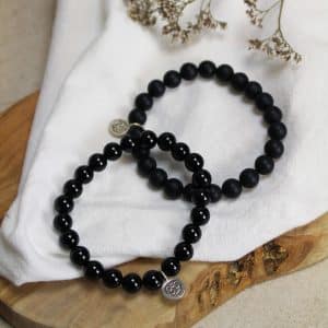 Armband Onyx met ohm teken ONYX IS EEN STERKE STEEN, ZOWEL EMOTIONEEL ALS FYSIEK. DE STEEN GEEFT JE ZELFVERTROUWEN, STABILITEIT, HELPT JE TE GRONDEN EN OM TE FOCUSSEN, GEEFT MOED EN BESCHERMING. ONYX ZET NEGATIVITEIT OM IN POSITIVITEIT, HELPT GRENZEN TE STELLEN EN OM MEER CONTROLE TE HEBBEN OVER JE EIGEN DENKEN EN HANDELEN. ONYX HELPT JE IN TIJDEN VAN VERDRIET. DE STEEN VERSTERKT DE HUID, NAGELS EN HET HAAR. ONYX HEEFT OOK EEN GOEDE INVLOED OP HET LYMFESYSTEEM EN OP HET GEHOOR. DE ONDERSTEUNENDE WERKING MAAKT DAT ONYX EEN GOEDE STEEN IS VOOR OP DE WERKPLEK. ONYX IS EEN WARE SPONS DUS HET IS RAADZAAM OM HEM WEKELIJKS TE REINIGEN ALS JE HEM REGELMATIG DRAAGT. MEDITATIE: V WATER: V KIND: X ZON: V