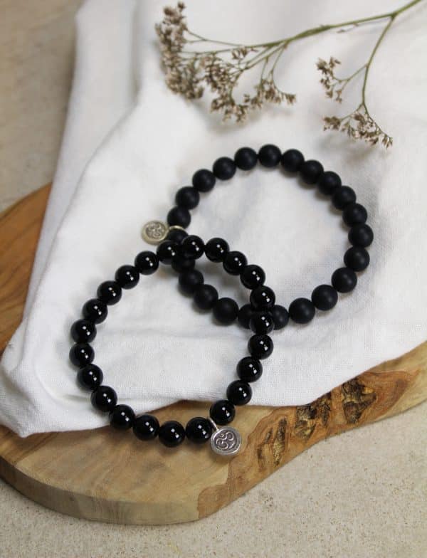 Armband Onyx met ohm teken ONYX IS EEN STERKE STEEN, ZOWEL EMOTIONEEL ALS FYSIEK. DE STEEN GEEFT JE ZELFVERTROUWEN, STABILITEIT, HELPT JE TE GRONDEN EN OM TE FOCUSSEN, GEEFT MOED EN BESCHERMING. ONYX ZET NEGATIVITEIT OM IN POSITIVITEIT, HELPT GRENZEN TE STELLEN EN OM MEER CONTROLE TE HEBBEN OVER JE EIGEN DENKEN EN HANDELEN. ONYX HELPT JE IN TIJDEN VAN VERDRIET. DE STEEN VERSTERKT DE HUID, NAGELS EN HET HAAR. ONYX HEEFT OOK EEN GOEDE INVLOED OP HET LYMFESYSTEEM EN OP HET GEHOOR. DE ONDERSTEUNENDE WERKING MAAKT DAT ONYX EEN GOEDE STEEN IS VOOR OP DE WERKPLEK. ONYX IS EEN WARE SPONS DUS HET IS RAADZAAM OM HEM WEKELIJKS TE REINIGEN ALS JE HEM REGELMATIG DRAAGT. MEDITATIE: V WATER: V KIND: X ZON: V