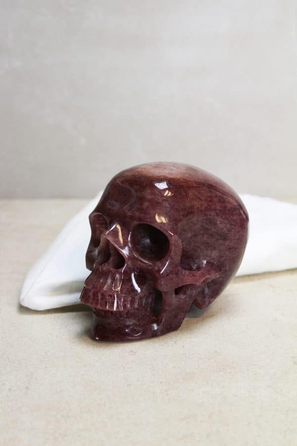 Skull van Cherry kwarts  Elke Skull uit onze collectie is een meesterwerk van de natuur (en de slijper).  De schedelvorm, symbool van wijsheid en kennis, is samengevoegd met de helende en opbeurende eigenschappen van Cherry kwarts. Een kristallen doodskop wordt vaak gezien als krachtige beschermer en kan helpen bij heling en het brengen van levensvreugde.