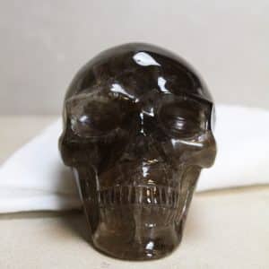 Skull van rookkwarts  Elke Skull uit onze collectie is een meesterwerk van de natuur (en de slijper).  De schedelvorm, symbool van wijsheid en kennis, is samengevoegd met de stabiliserende werkzaamheden van de rookkwarts. Deze kristallen doodskop wordt gezien als krachtige beschermer en geeft een positieve energie af.